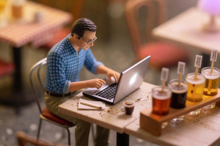 Miniature figure completing alcohol training on a laptop